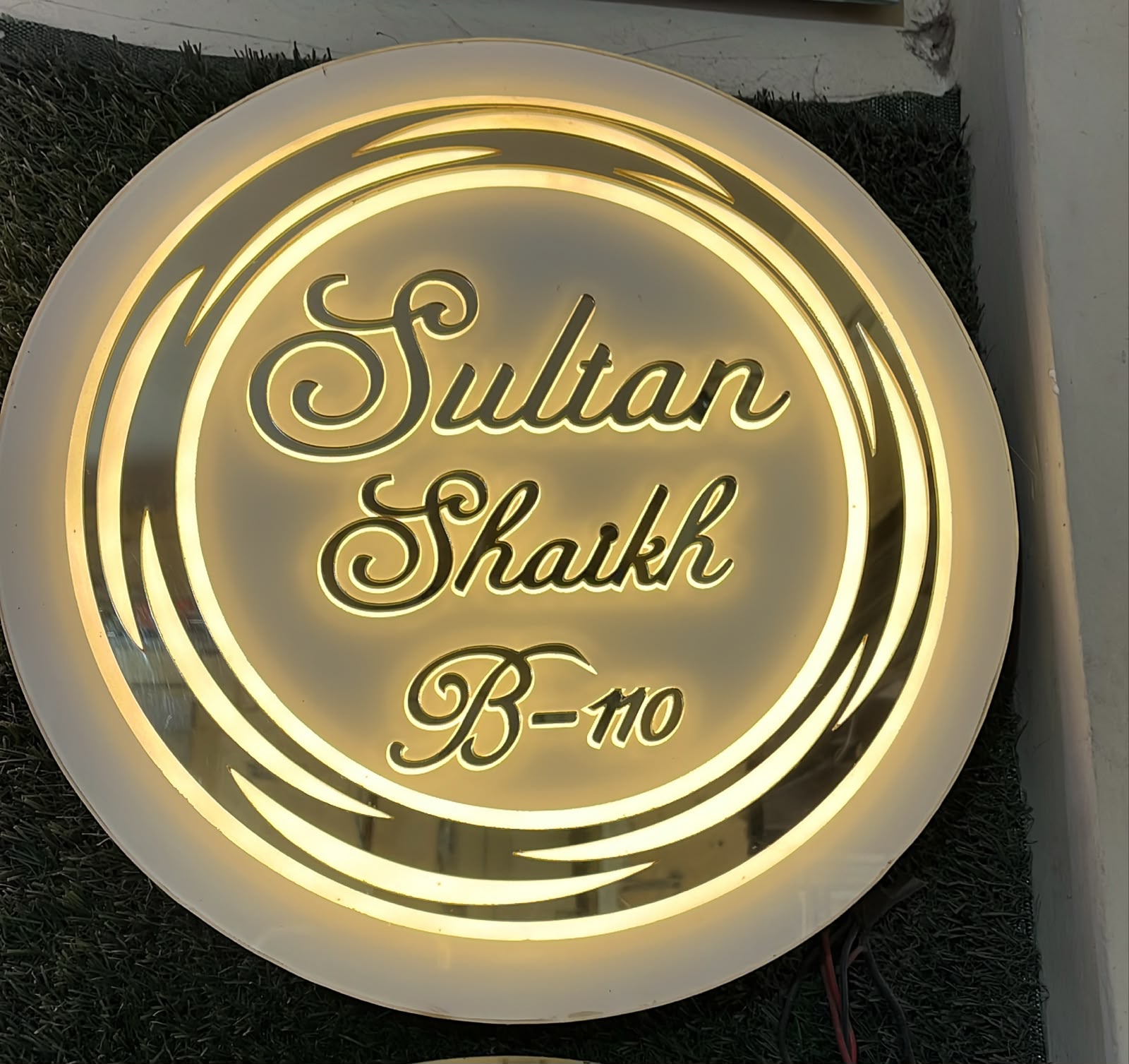 Original photograph of a circular illuminated custom nameplate